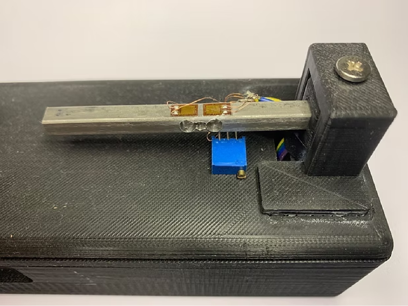 Close-up of the steel load cell section with strain gauges and bridge balancing trim.